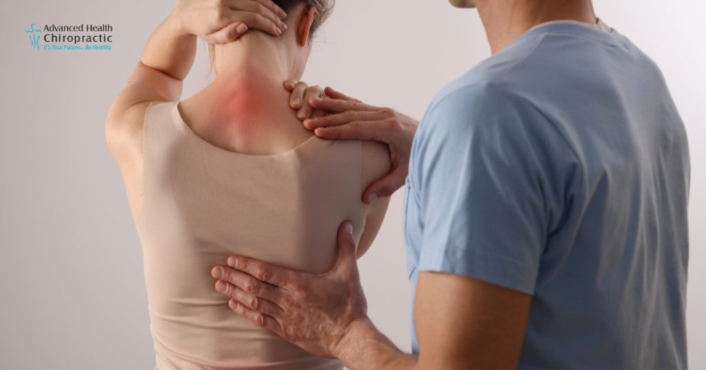 Middle-aged woman holding lower back in discomfort, representing fibromyalgia pain.
