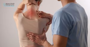 Middle-aged woman holding lower back in discomfort, representing fibromyalgia pain.