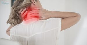 Person with poor posture experiencing neck pain at a desk